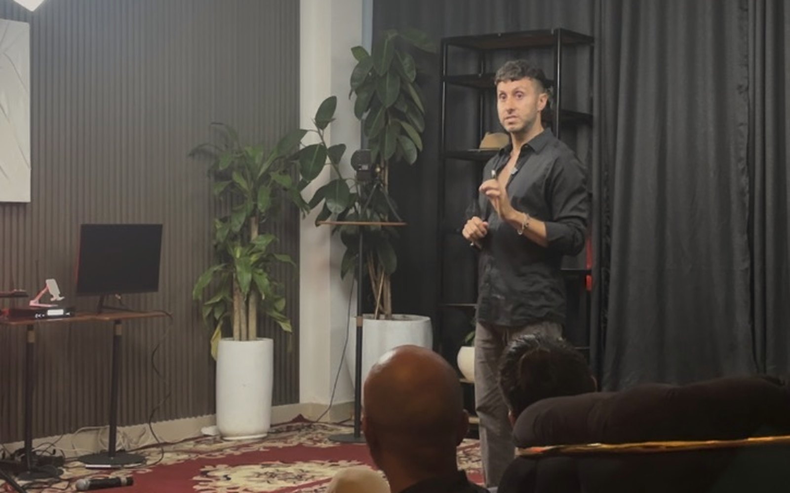 Cal Amir speaking to an intimate audience at a studio session